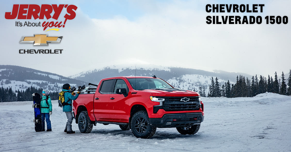 Chevrolet Silverado 1500 in snow with people getting ready to snowboard.
